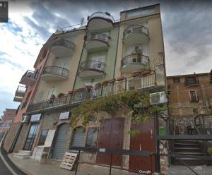 Un edificio alto con balcones a los lados. en CasaMIA a Marina di Camerota, en Marina di Camerota