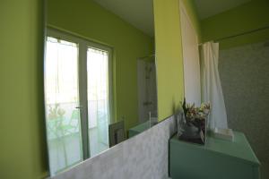 a bathroom with a mirror and a vase of flowers at STANZINA DELLA BARONESSA in Carini