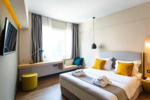 1 dormitorio con 1 cama grande y toallas. en St. Bjur Suites, en Atenas