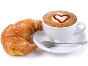 uma chávena de café e um croissant num prato em Casa degli Artisti Diamante em Diamante