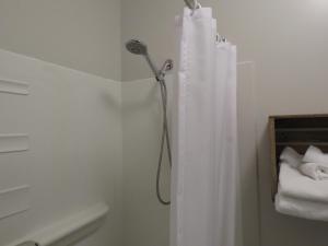 y baño con ducha y cortina de ducha. en Le Ste-Hélène Auberge & Spa, en Sainte-Hélène-de-Chester