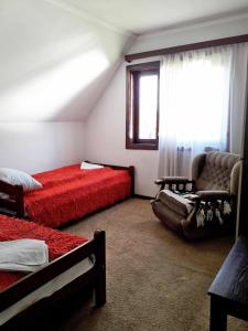 1 dormitorio con 2 camas, silla y ventana en Old Guest House 1964 en Žabljak