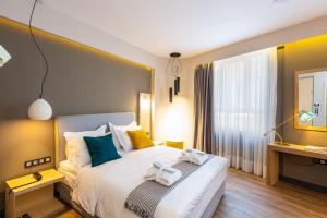 1 dormitorio con 1 cama con toallas en St. Bjur Suites, en Atenas