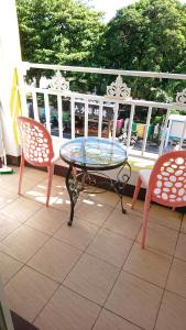 a glass table and two chairs on a balcony at Siaowan Homestay in Kenting