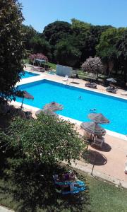 a large blue swimming pool with umbrellas and chairs at Studio in Hercules with pool and sea view in Benalmádena
