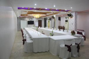 a large banquet hall with white tables and chairs at Hotel The Leschanze in Lahore