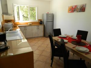 a kitchen with a table and a kitchen with a refrigerator at Au Clos des Faysses in Orgnac-lʼAven