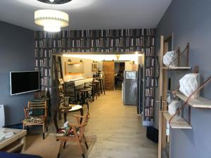 a room with a hallway with chairs and a tv at Le Bouquiniste, atypique, cosy, fibre, BedinShop in Romans-sur-Isère