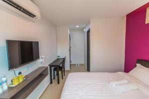 a hotel room with a bed, television, and a dresser at U Plus Budget Hotel in Bukit Mertajam