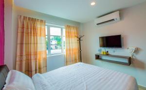 a bedroom with a bed and a tv and a window at U Plus Budget Hotel in Bukit Mertajam