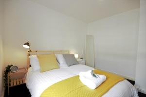 a bedroom with a large bed with a yellow blanket at HU1 City Centre Hub (sleeps 6) in Hull