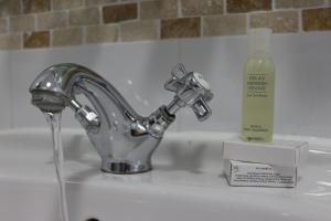 
a white sink with a toothbrush in it at Gairloch Hotel 'A Bespoke Hotel' in Gairloch
