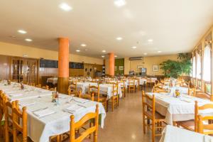 un comedor con mesas blancas y sillas amarillas en Hotel Costa, en El Pont de Suert