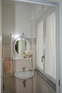 ein weißes Badezimmer mit einem Waschbecken und einem Spiegel in der Unterkunft Ica house in Castellammare di Stabia