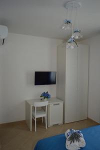 una stanza con un letto, una scrivania e una TV di Ica house a Castellammare di Stabia