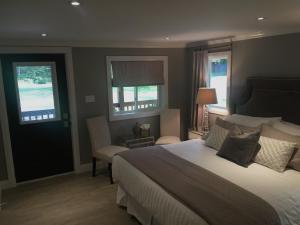 a bedroom with a large bed and two windows at Somerset Lakeside Resort in Bancroft