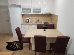 - une cuisine avec une table et des chaises en bois dans l'établissement Apartment Centar LUX, à Banja Luka