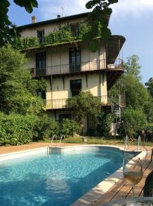 a hotel with a swimming pool in front of a building at Le Grand Chalet in Aspet