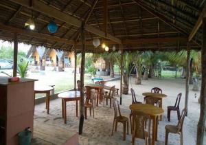 a group of tables and chairs under a pavilion at Ceylon Antheia Beach Resort in Nilaveli
