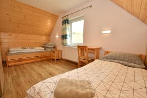 a bedroom with a bed and a desk and a window at Rekreačna usadlosť Pieninka in Lesnica