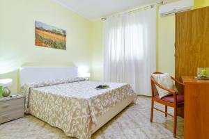 una camera con letto, scrivania e sedia di Green Paradise Affittacamere a SantʼAgata sui Due Golfi
