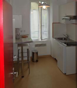 a small kitchen with a sink and a counter at Appartement d'Hôtes in Guéret