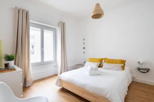 ein Schlafzimmer mit einem weißen Bett und einem Fenster in der Unterkunft Harmonie by Cocoonr in Nantes