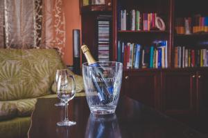 uma garrafa de champanhe num copo numa mesa com dois copos em Apartment and Room Tacy em Opatija