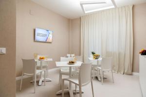 une salle à manger avec des tables et des chaises blanches dans l'établissement B&B Blanc, à Pescara