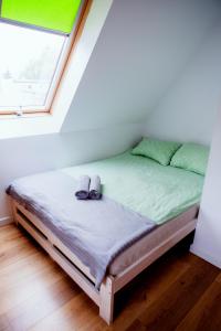 a bed with shoes on it in a room with a window at Hostel 55 - darmowy parking in Wrocław