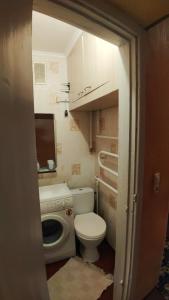 uma pequena casa de banho com WC e máquina de lavar roupa em квартира на вулиці Лесі Українки em Uzyn