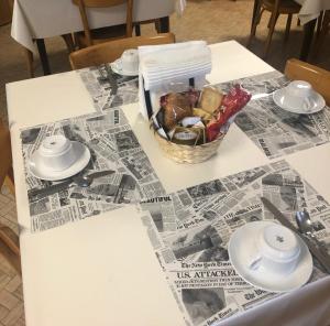 een tafel met een mand met eten en een krant bij Ostello di Germagno in Omegna