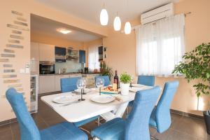 une salle à manger avec une table blanche et des chaises bleues dans l'établissement Apartment Maja with private pool, à Sveti Petar