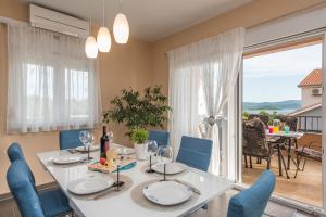 a dining room with a white table and blue chairs at Apartment Maja with private pool in Sveti Petar