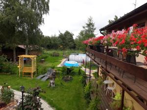 a backyard with a garden with flowers and a building at Dworska Zagroda in Korytowo