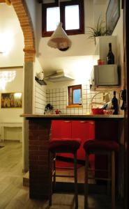 a kitchen with a red counter and two stools at Conte Canacci in Florence