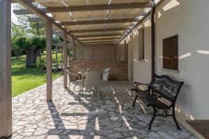 a patio with a table and chairs under a pergola at Le Maraclà Country House in Iesi