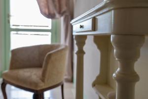 una silla sentada junto a un tocador con un cajón en Le Maraclà Country House, en Iesi