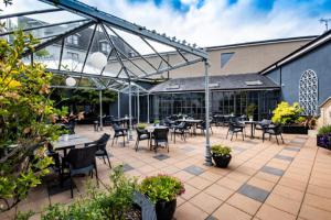 um pátio exterior com mesas, cadeiras e plantas em Midlands Park Hotel em Portlaoise
