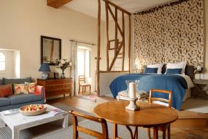 a living room with a bed and a table at Le Domaine de Fleury - Pierres d'Histoire in Fleury-en-Bière