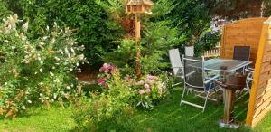 a garden with a table and a bird feeder and flowers at Ferienwohnung Stadtvilla in Magdeburg
