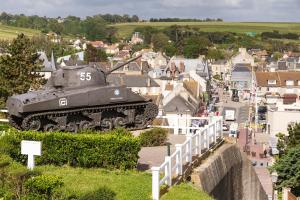 a tank sitting on top of a hill near a city at Les Villas d'Arromanches, Teritoria in Arromanches-les-Bains