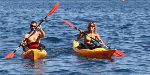 twee mensen in kajaks in het water bij Pensión Hostel Costa Brava in L'Estartit