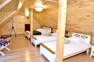 a room with four beds in a wooden cabin at Căsuța de Poveste in Tîrgu Neamţ