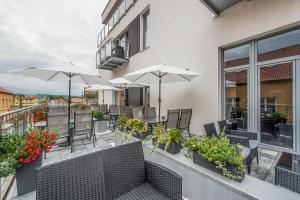 a balcony with chairs and umbrellas on a building at Hotel Black Horse in Prešov