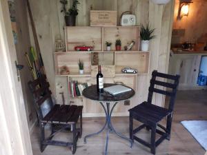 een tafel met een fles wijn en twee stoelen bij La cabane du pêcheur in Montcuq