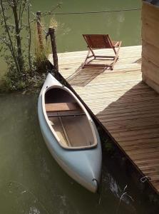 a small boat sitting on the water next to a dock at La cabane du pêcheur in Montcuq