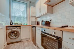 a kitchen with a washer and a dishwasher at Central Park Place in Whitby