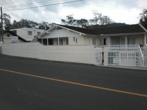 a white fence in front of a white house at Pousada Luiza in Pomerode