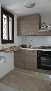 a kitchen with wooden cabinets and a sink and a stove at Mamma Rosa in Trecase